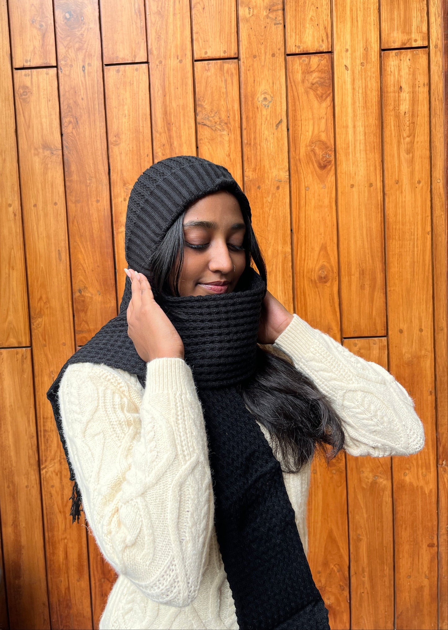 Woman wearing black woollen cap with attached scarf – Madhuri Woollens