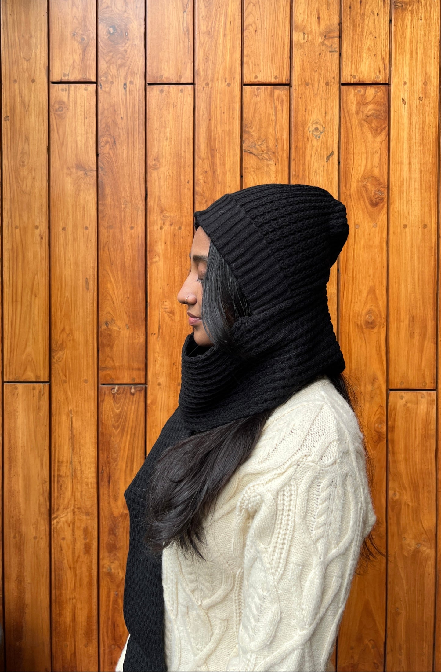 Woman wearing black woollen cap with attached scarf – Madhuri Woollens