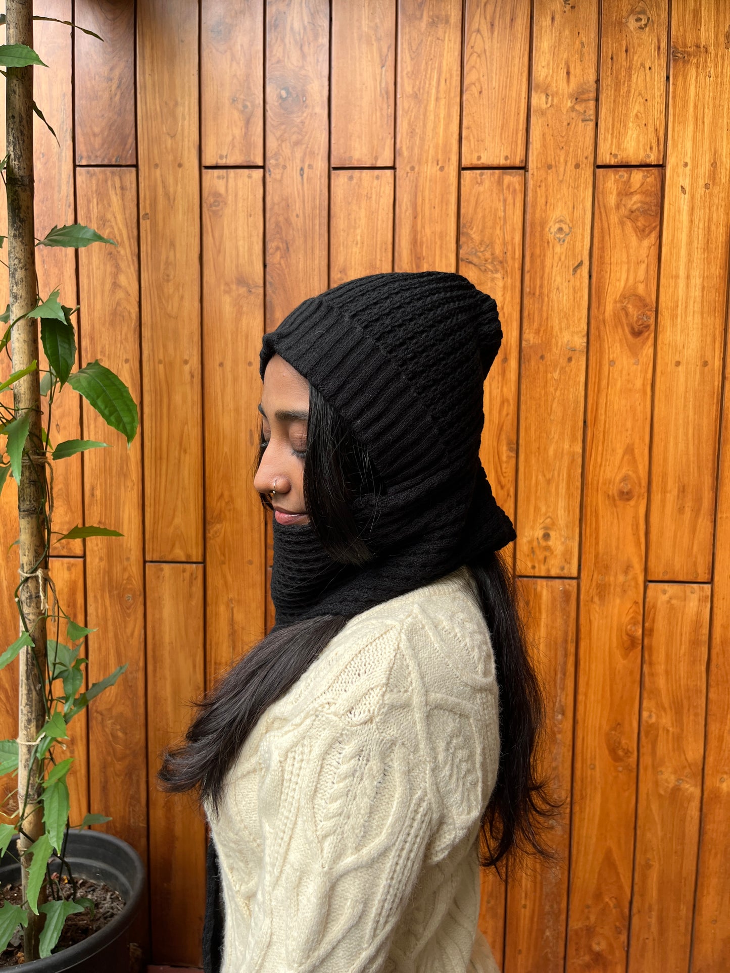 Woman wearing black woollen cap with attached scarf – Madhuri Woollens