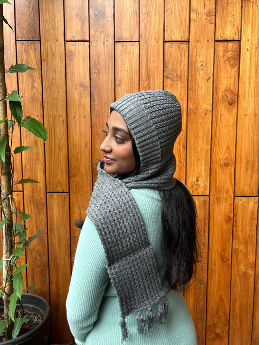 Woman wearing grey cap with attached scarf – Madhuri Woollens winter accessory