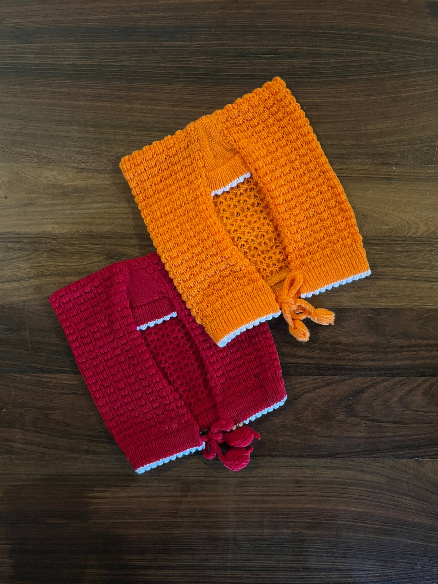 Hand-knitted wool baby sasa caps in red and orange