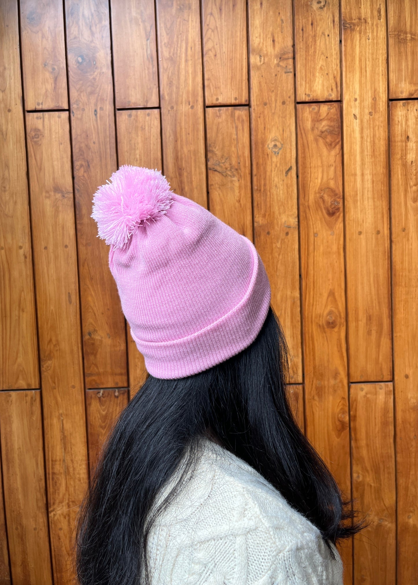 Pink woollen cap with pom-pom worn by woman – Madhuri Woollens