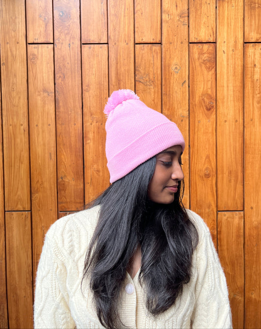Pink woollen cap with pom-pom worn by woman – Madhuri Woollens