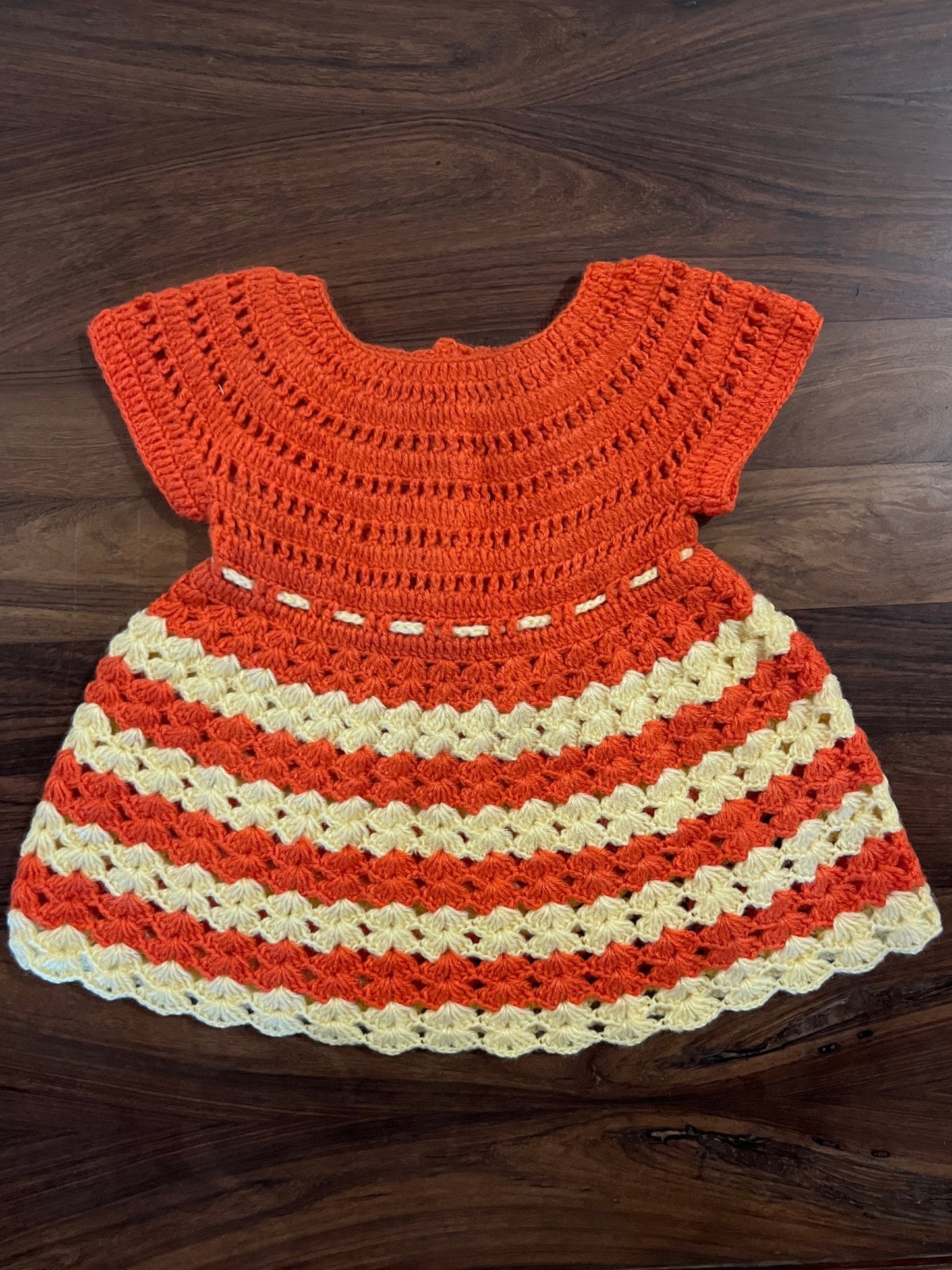 Handmade orange and cream crochet baby frock by Madhuri Woollens