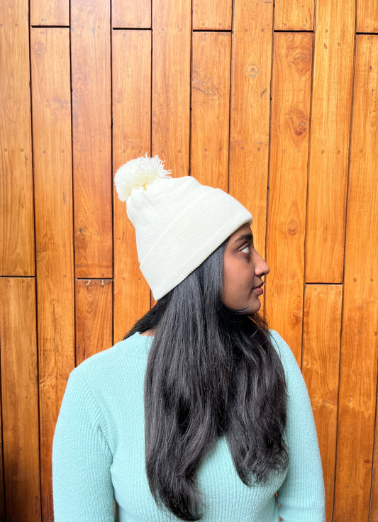 Woman wearing soft white woollen cap with pom-pom – Madhuri Woollens