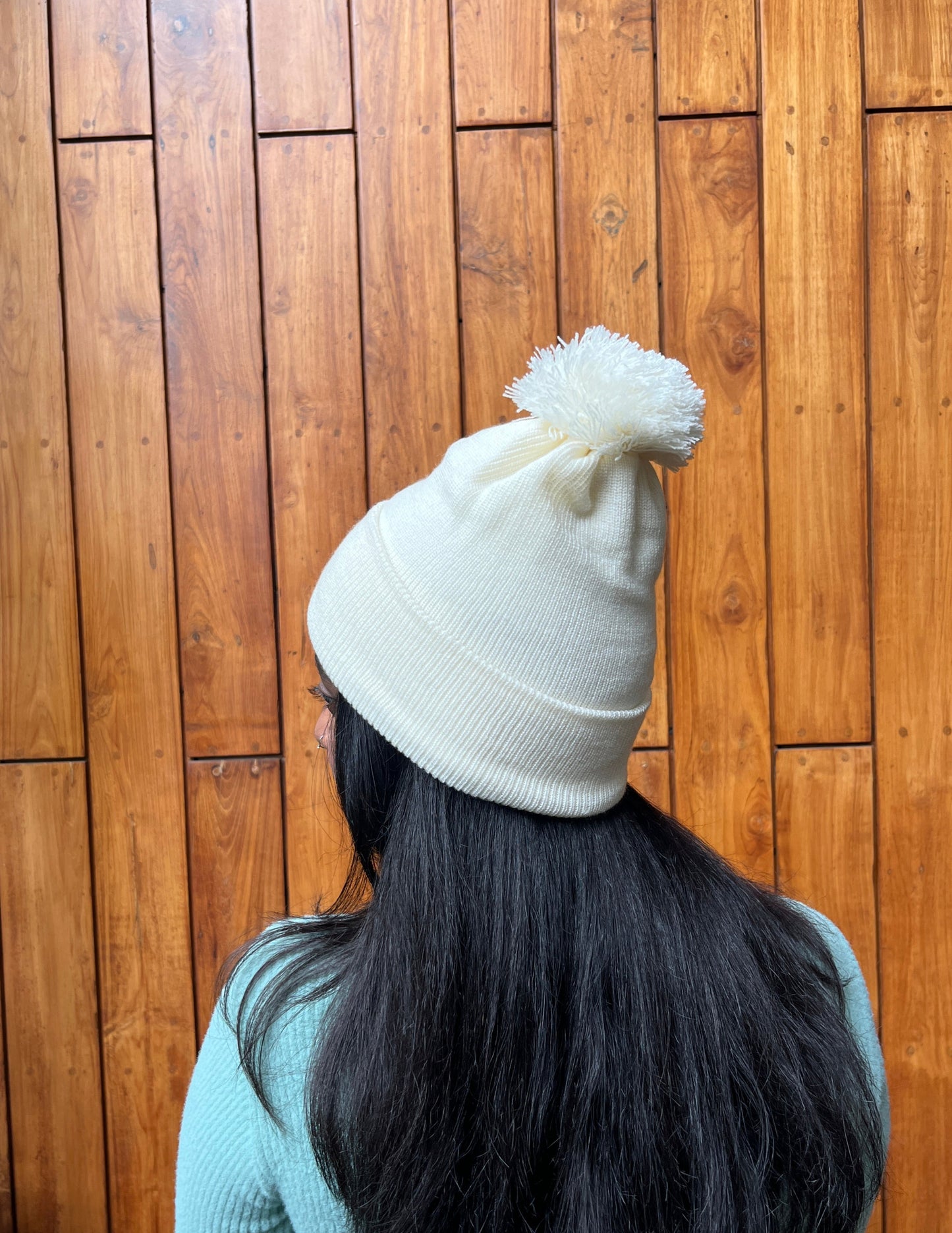 Woman wearing soft white woollen cap with pom-pom – Madhuri Woollens