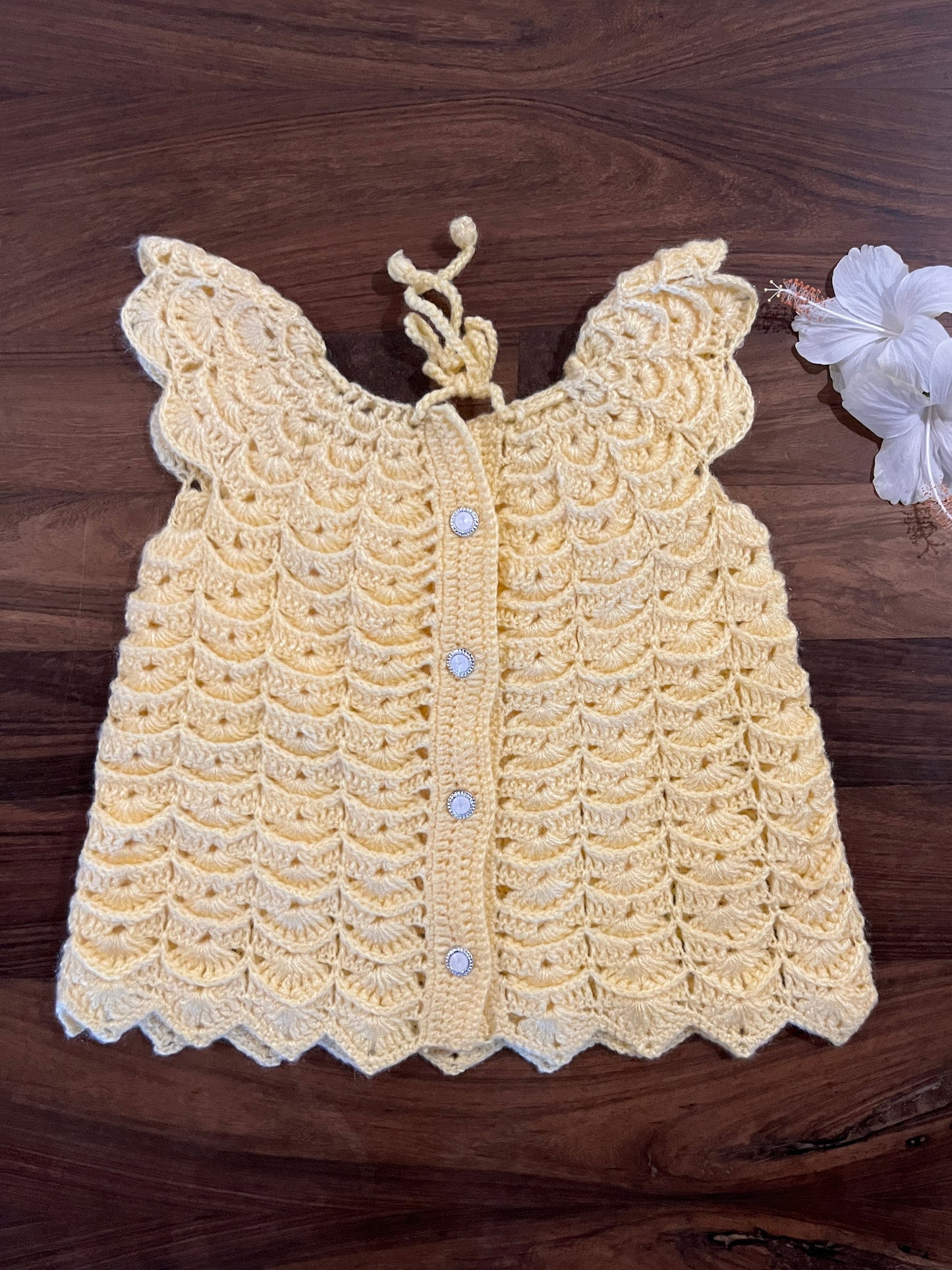 handmade yellow crochet baby dress with scalloped design