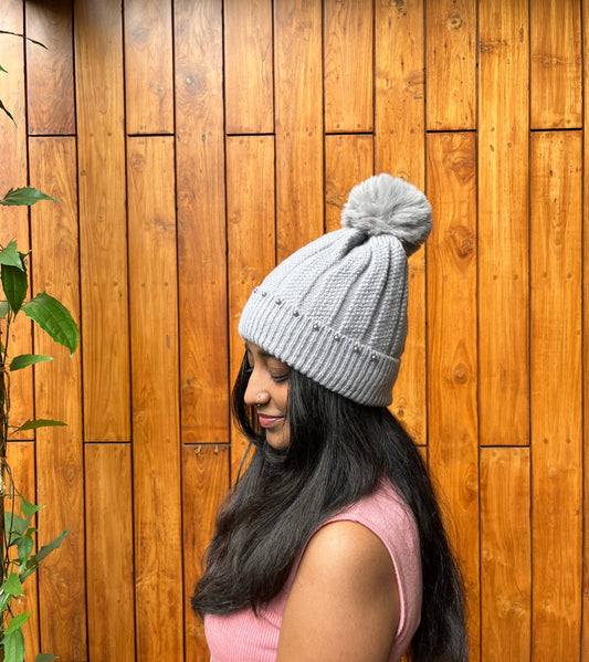 Grey woolen cap with pom-pom and pearl detail – winter accessory by Madhuri Woollens