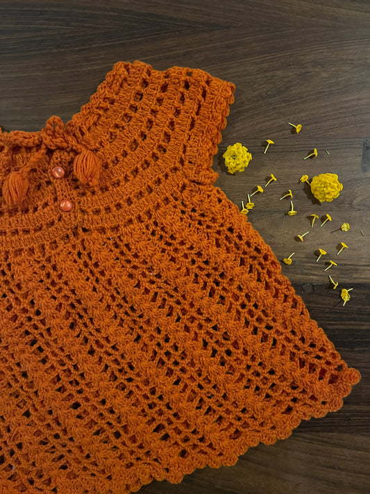 orange handmade crochet baby dress with tassel ties