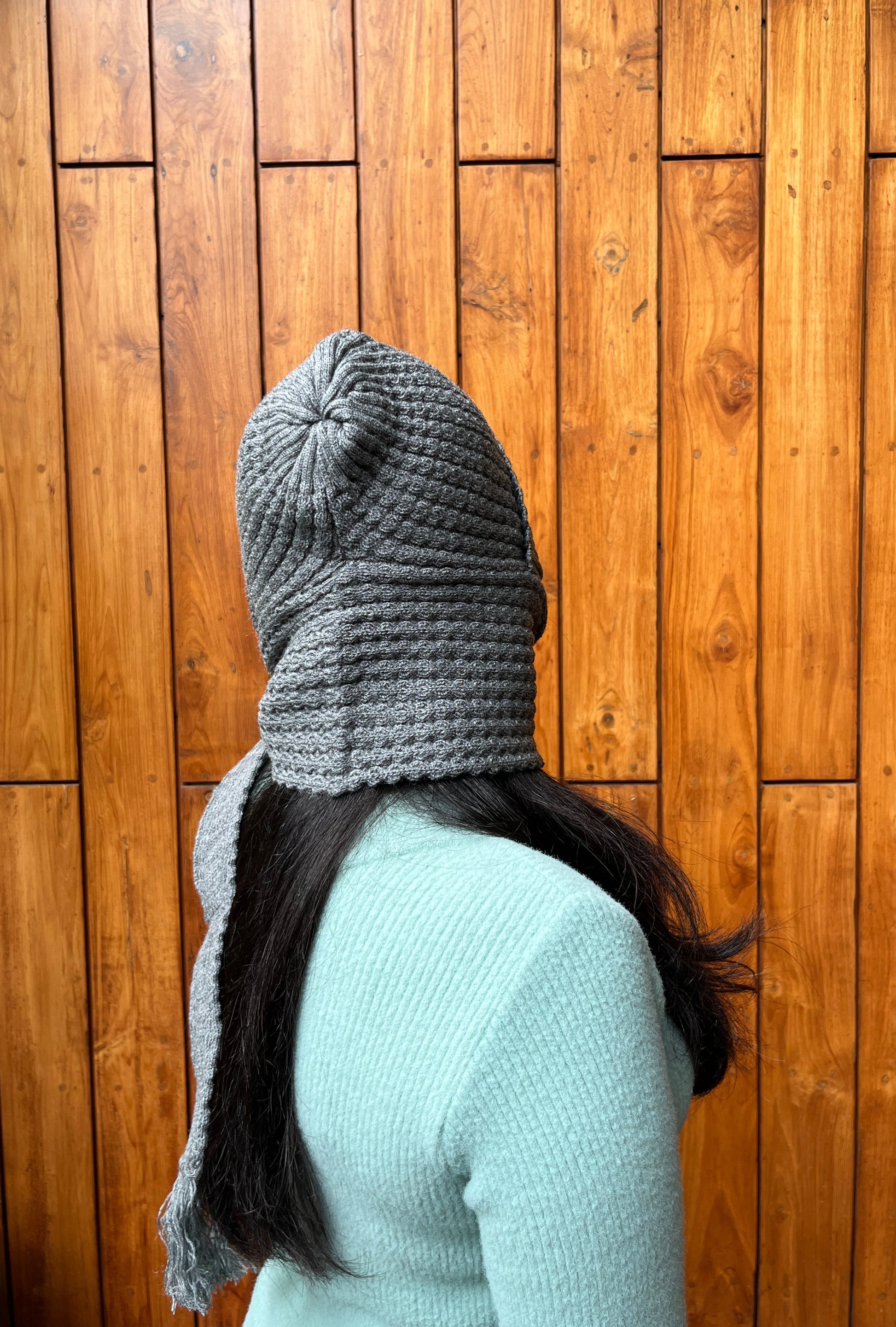 Woman wearing grey cap with attached scarf – Madhuri Woollens winter accessory