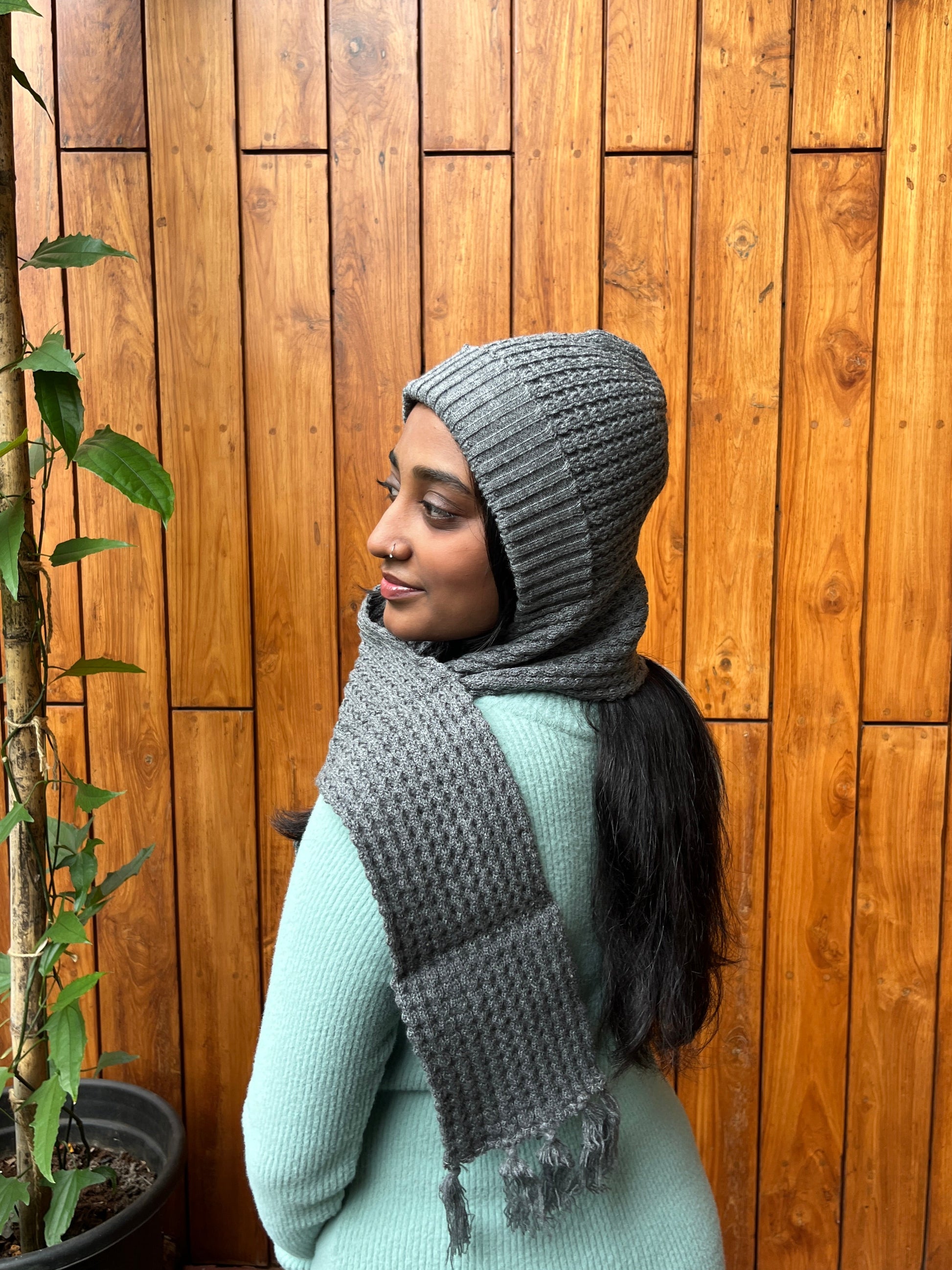 Woman wearing grey cap with attached scarf – Madhuri Woollens winter accessory