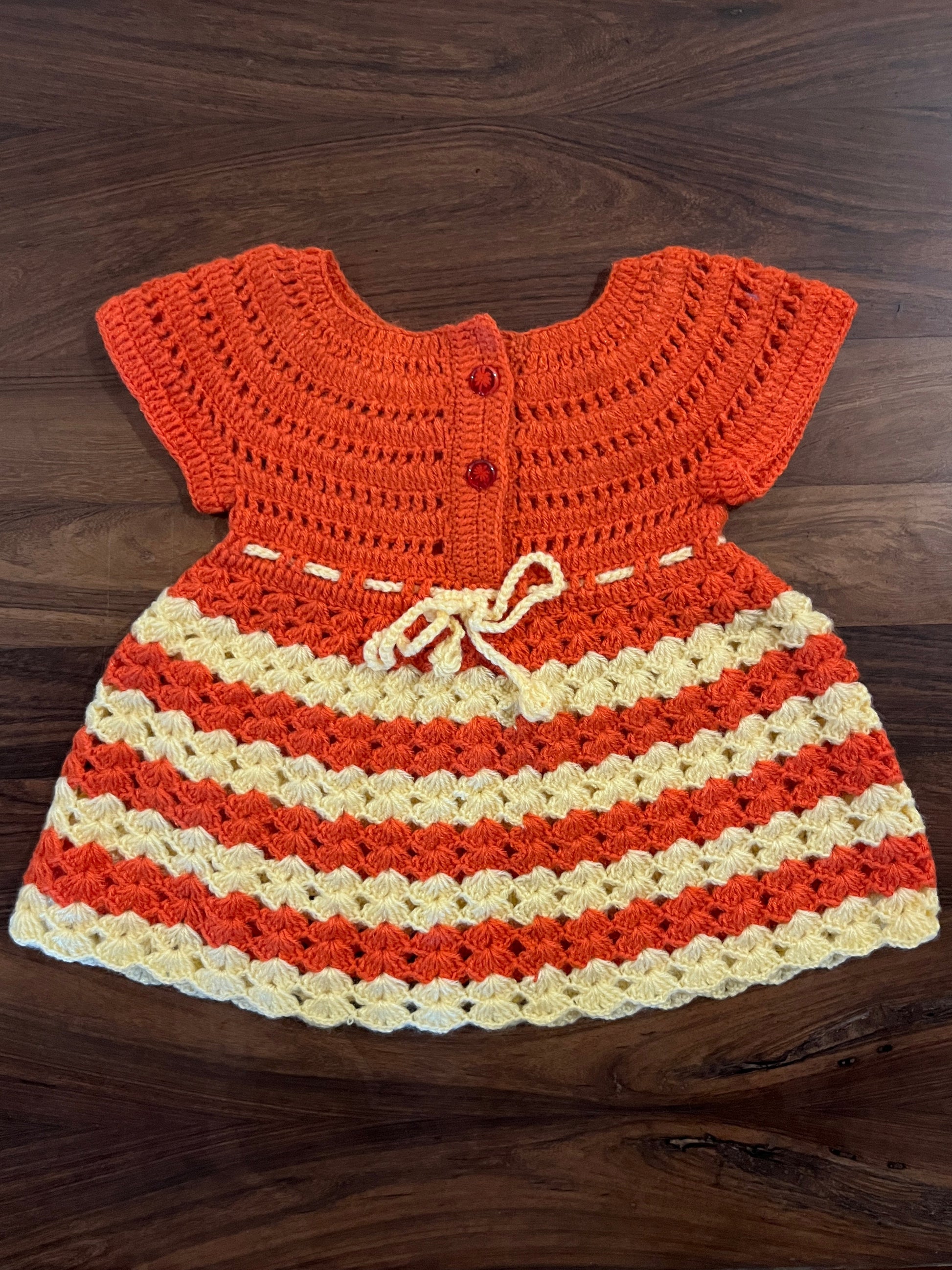 Handmade orange and cream crochet baby frock by Madhuri Woollens