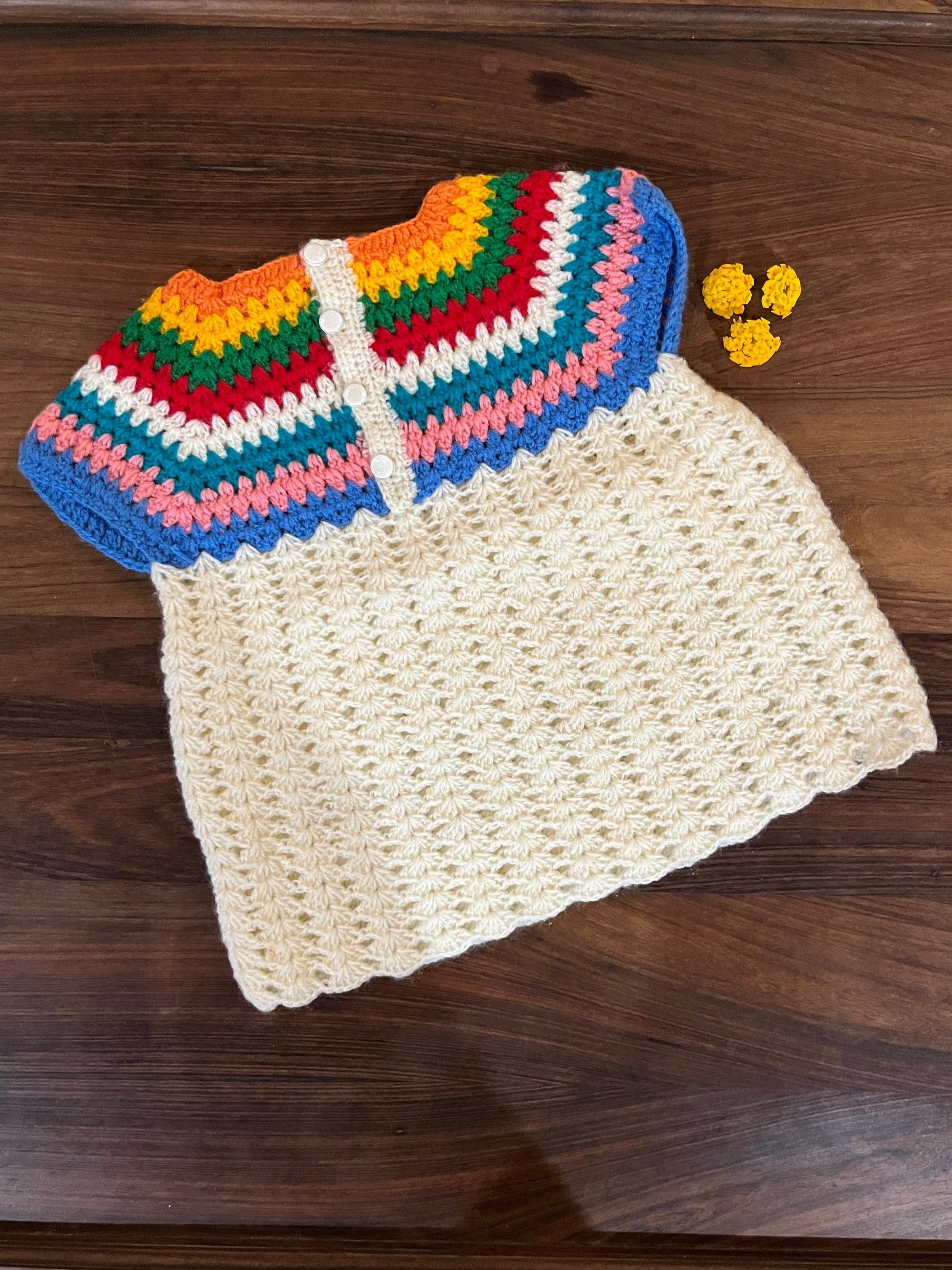 Handmade crochet baby dress with rainbow yoke and cream body for infants 12-24 months